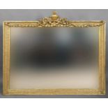 GILTWOOD OVERMANTEL MIRROR the rectangular plate beneath a crest of an urn and crossed musical