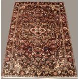 BAKTIARI CARPET West Iran, circa 1950, the aubergine field of flowering vines around a medallion