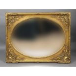LARGE GILT MIRROR the oval plate inside a frame with scrolling foliate spandrils, height 145cm,