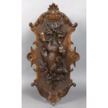 LARGE BLACK FOREST PLAQUE probably by Fluck, carved with a deer hanging before a rifle, spears,