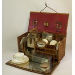 A Four-Person Picnic Set. Housed in a woven wicker fold-down front basket, the set comprises four