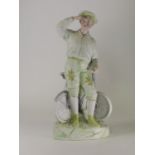 A Coloured Bisque Statuette, in the guise of a young man leaning against his bicycle. German, no