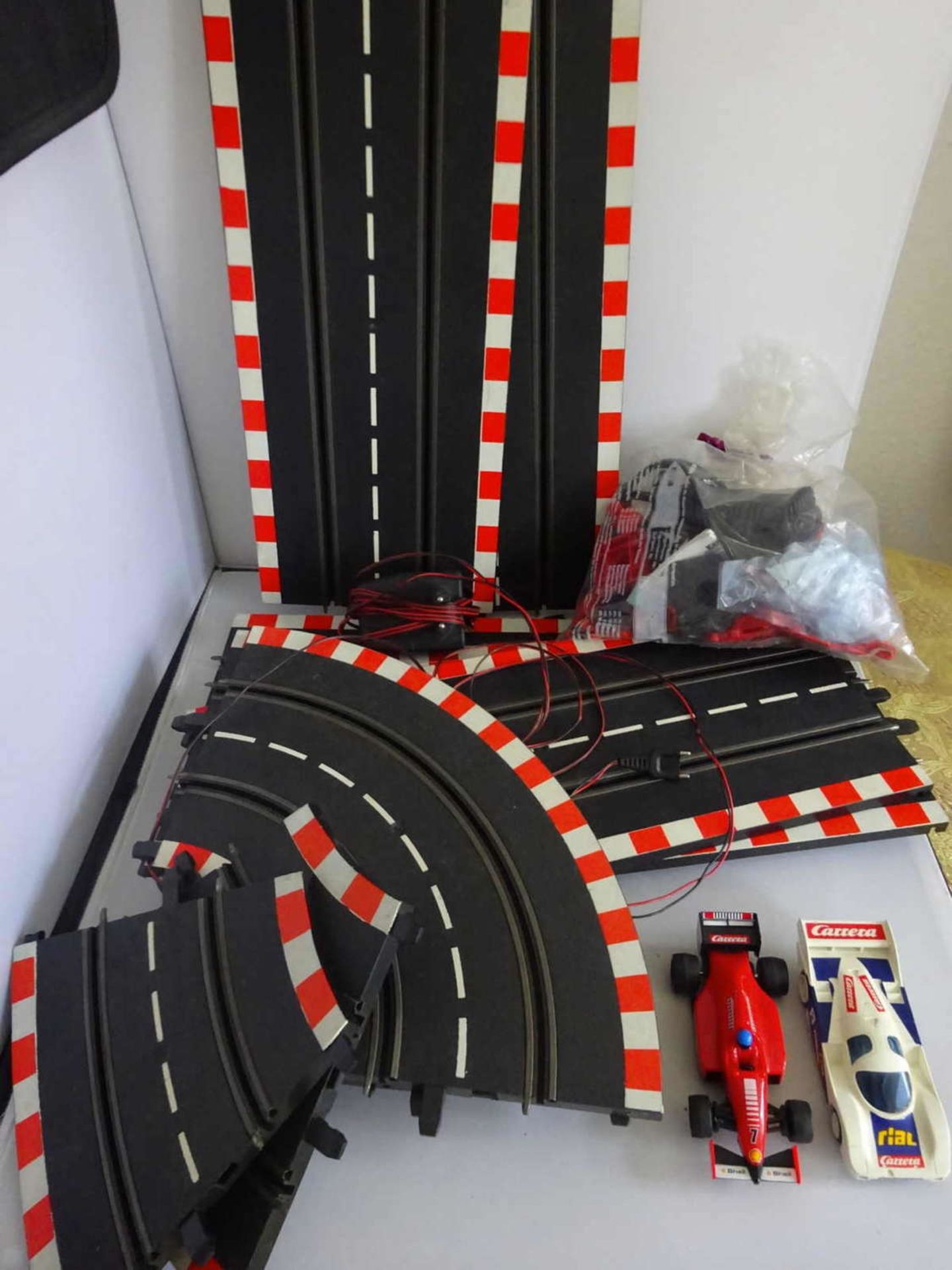 Carrera racetrack, with various parts, as well as 2 cars. Function not tested. Please visitCarrera