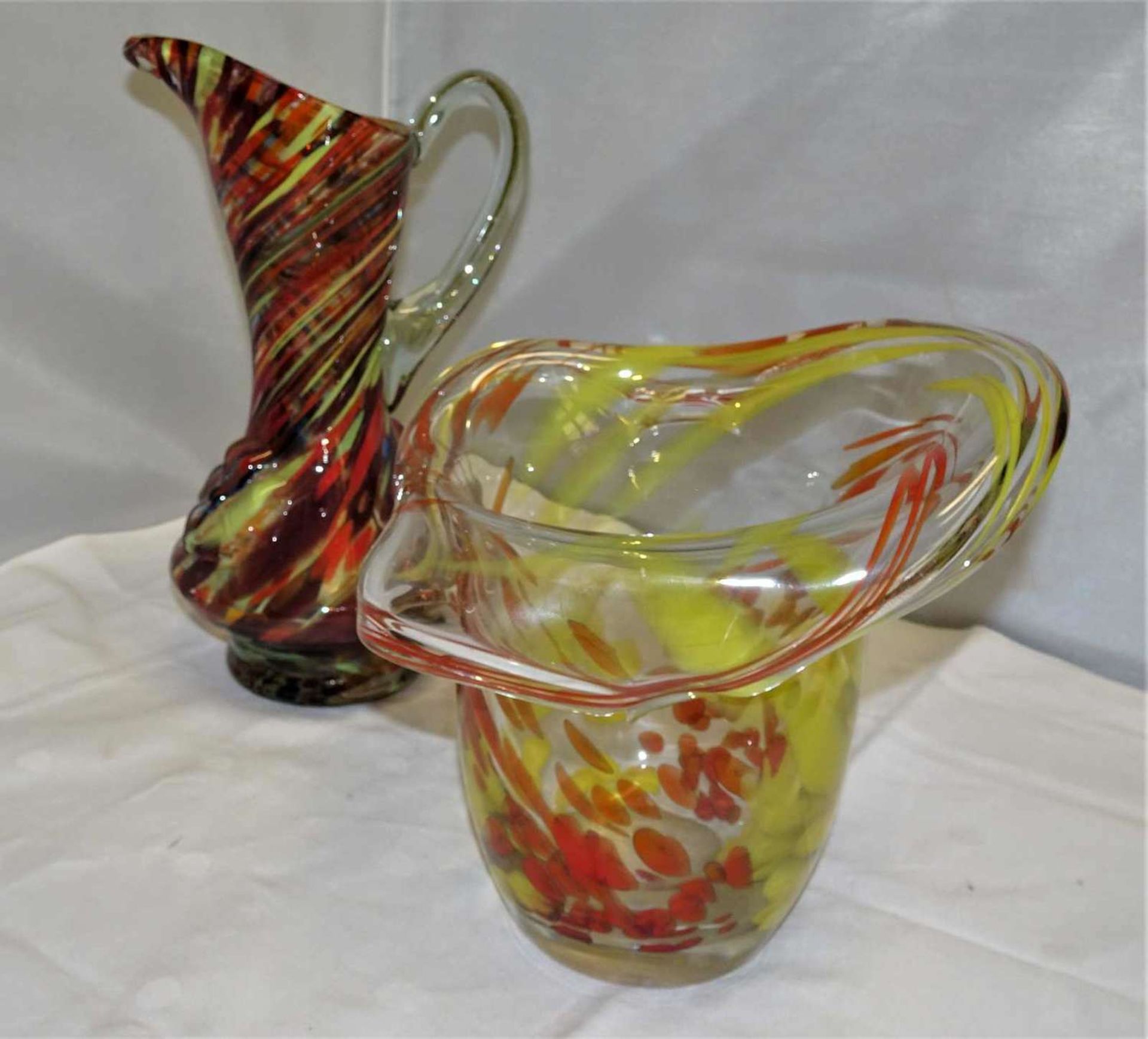 2Teile Murano Glas, 1x Henkelvase, sowie 1 Taschentuchvase. Beide mit orange/gelben Einschmelzungen.
