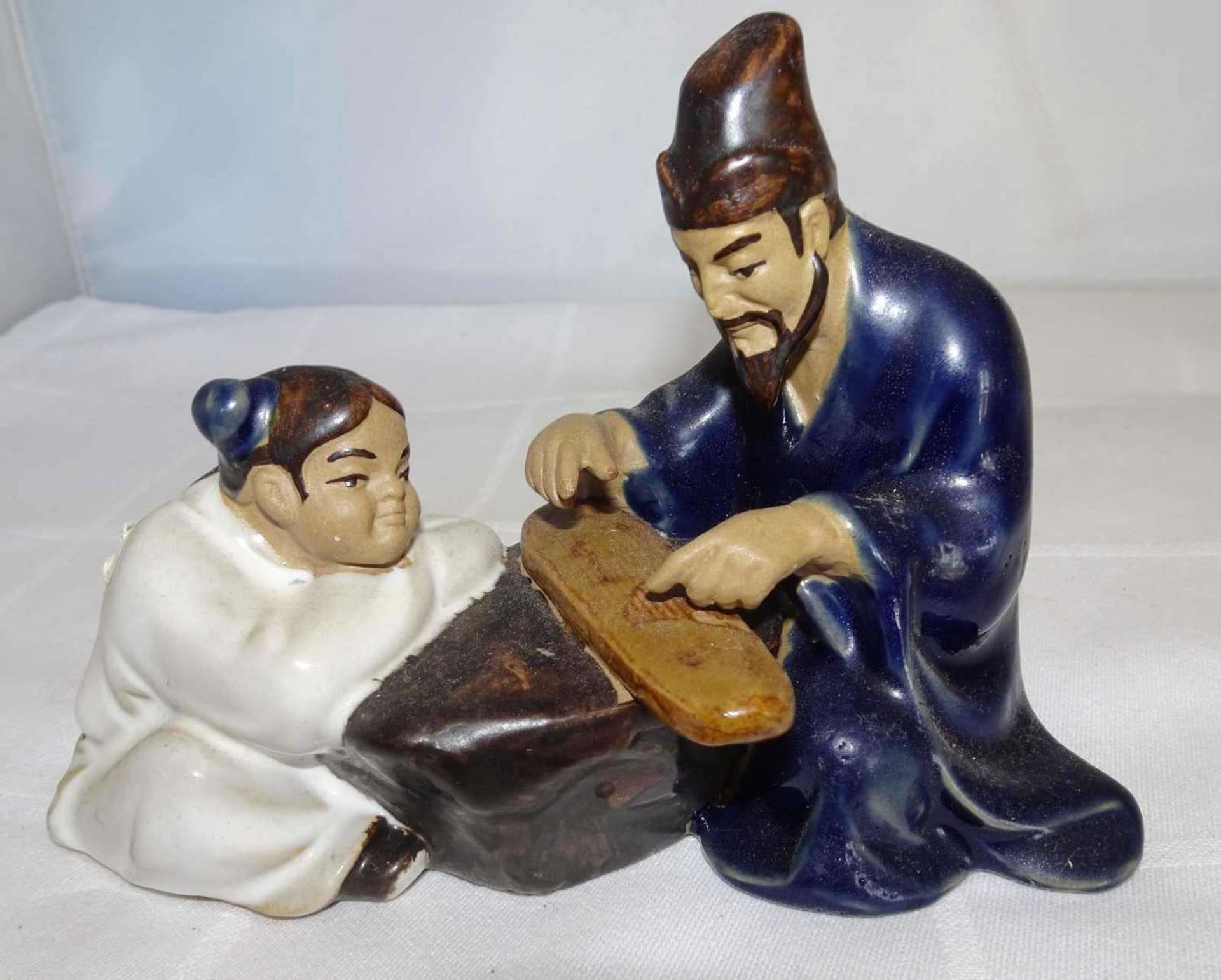 Keramikfigur "Vater & Sohn", am Boden gemarkt, farbig ausstaffiert. Höhe ca. 10,5 cm, Breite ca.