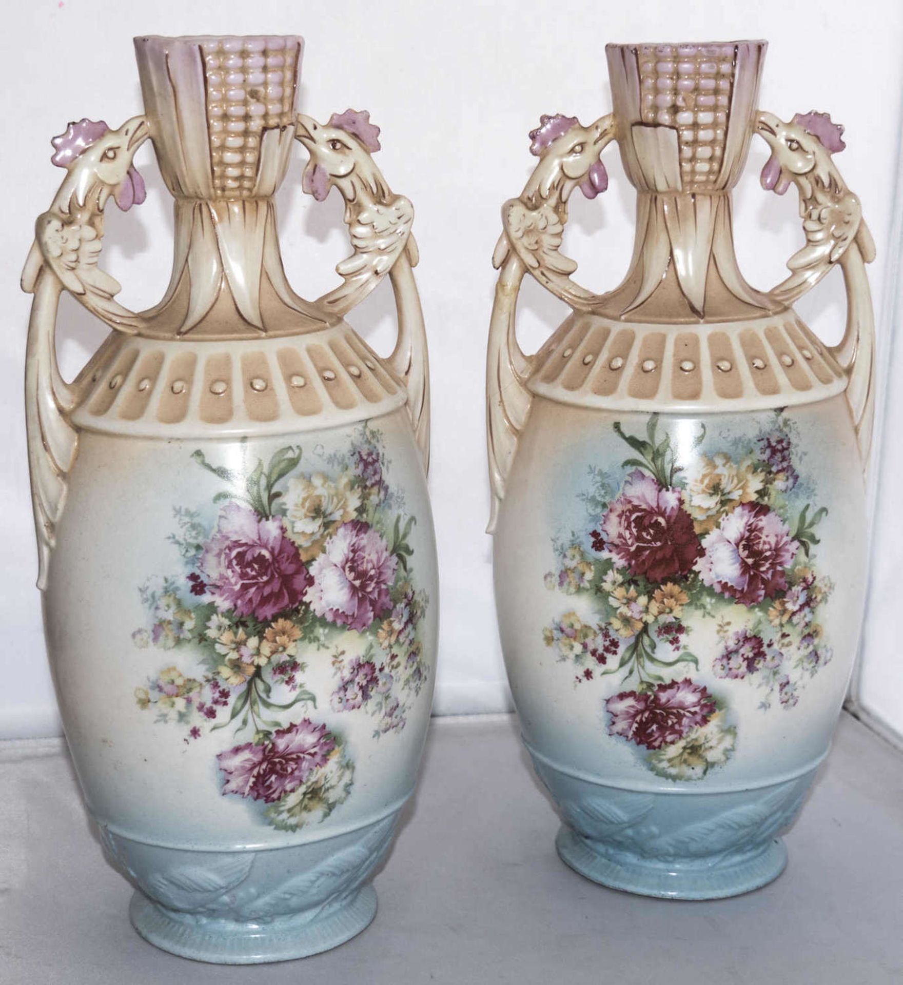 Ein Paar Keramikvasen in Amphorenform. Handhabe in Form von Vögelköpfen. Am Stand umlaufend
