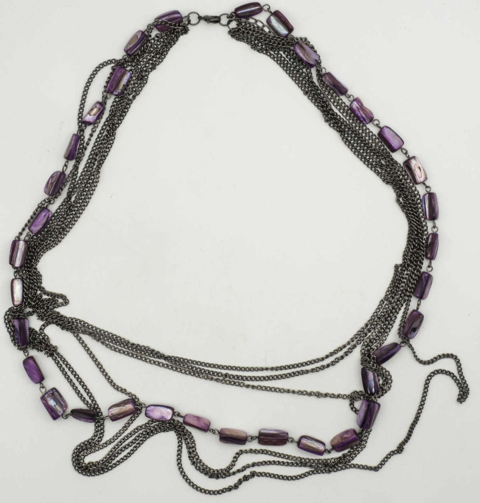 Kette, 7 - Stränge, davon eine mit violetten, irisierenden Steinen. Länge: ca. 66 cm.