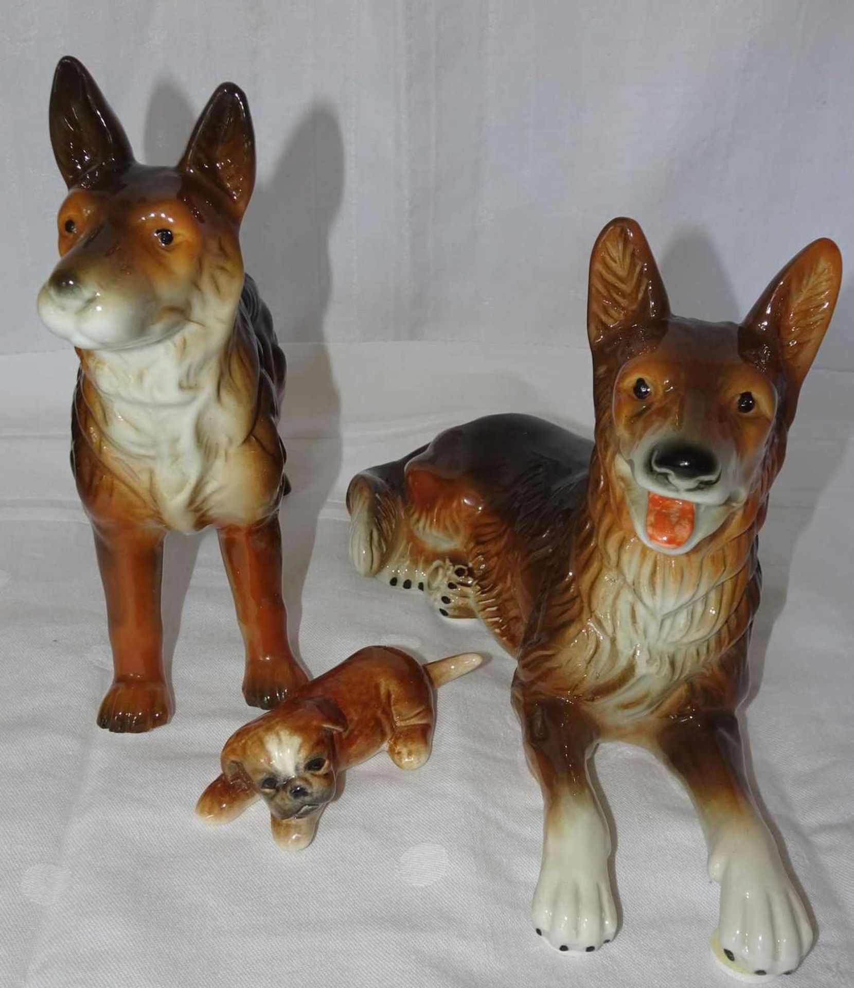 Lot Porzellanfiguren "Hunde", insgesamt 3 Stück. Verschiedene Modelle. Alle 3 Figuren gemarkt. Guter