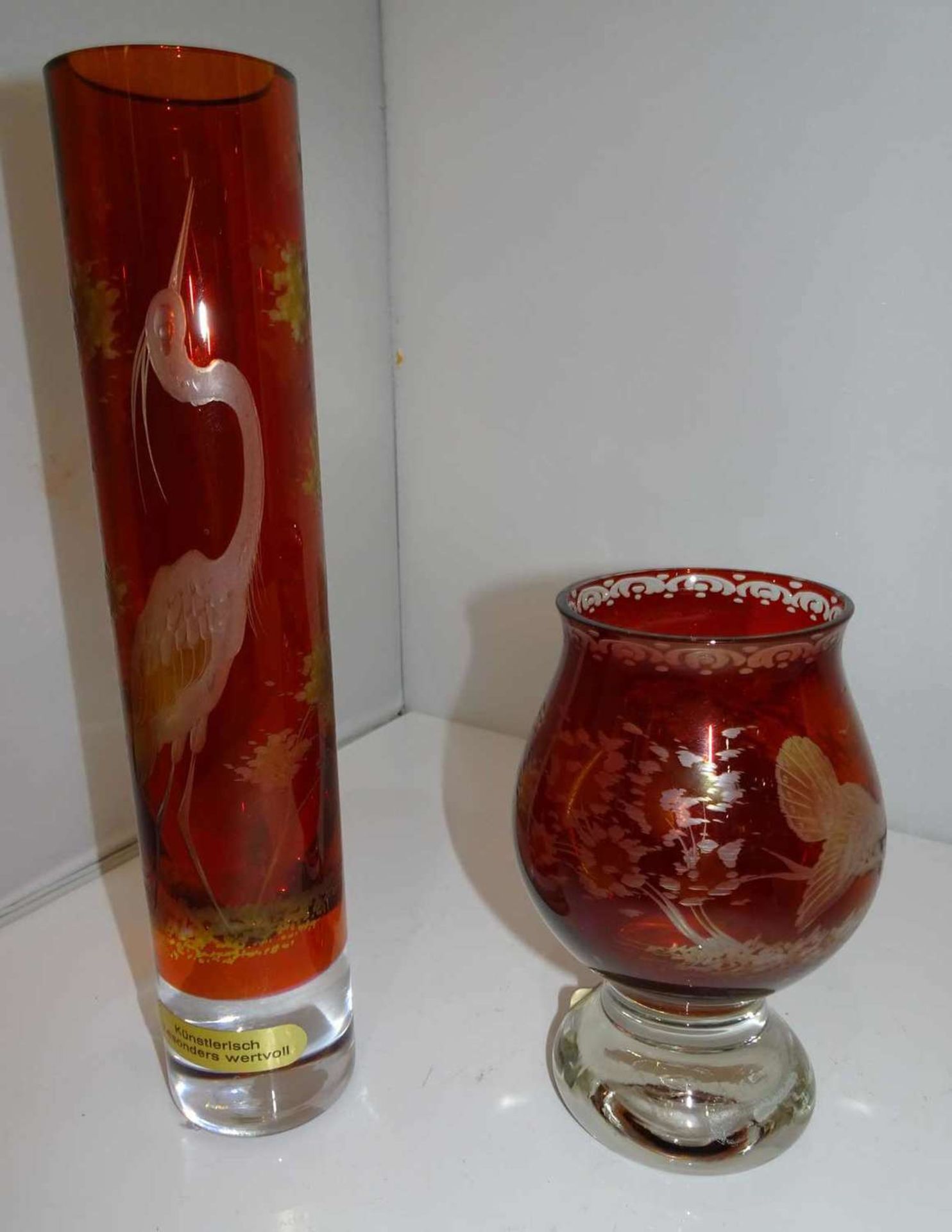 2 Bleikristallvasen, roter Überfang, handgeschliffen. 1x Stangenvase, Höhe ca. 28 cm, 1x Pokalvase,