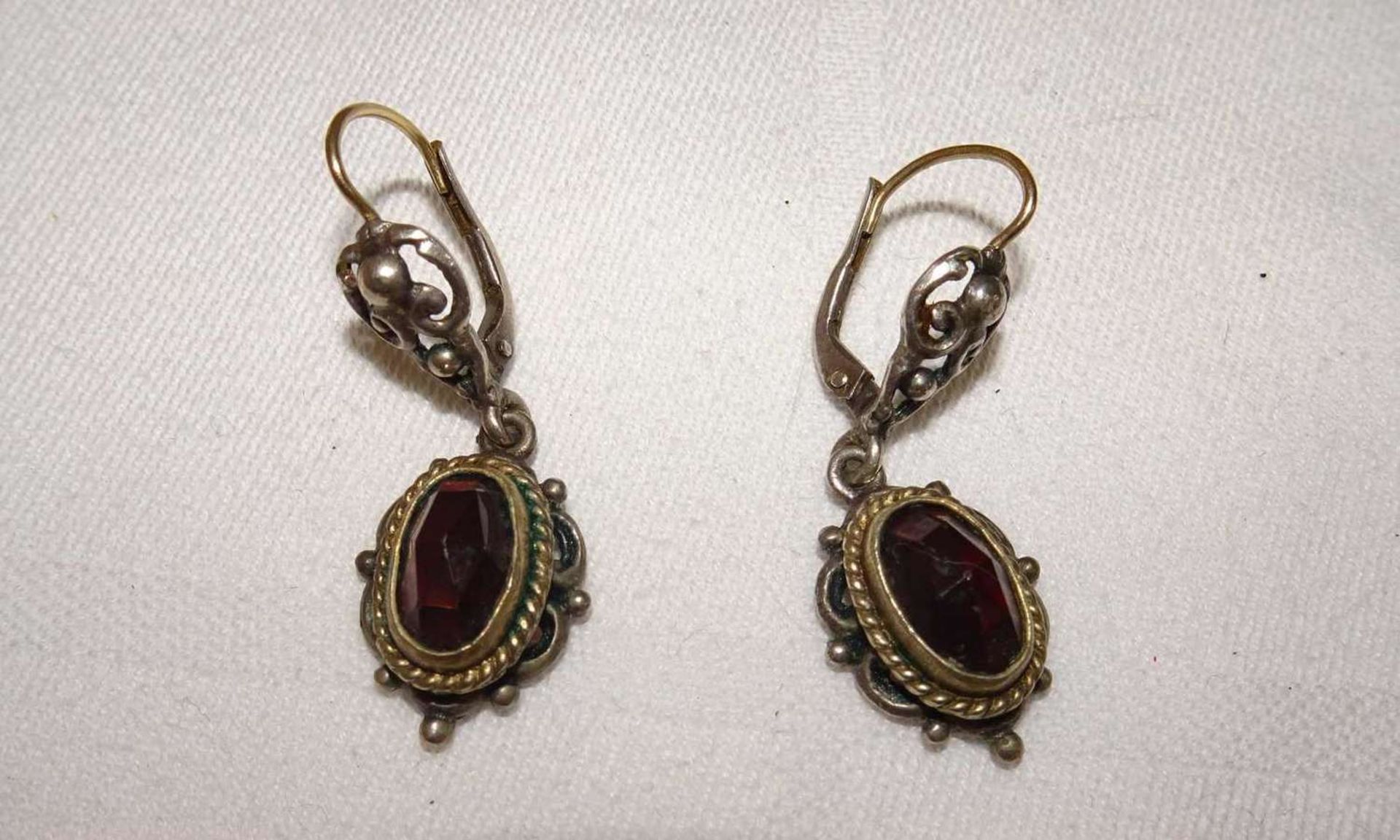 1 Paar Silberohrringe besetzt mit je 1 Granat. 1 pair of silver earrings each set with 1 garnet.