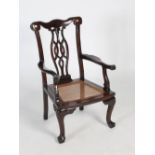 A Chinese dark wood armchair of Western style, Qing Dynasty, the scroll carved top rail enclosing an