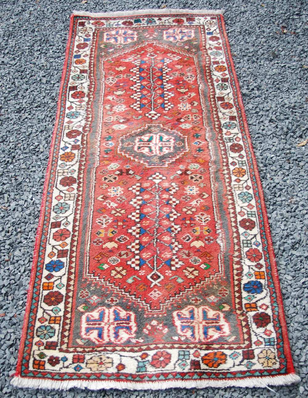 A Persian runner, 20th century, the rectangular madder ground centred with an octagonal shaped