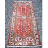 A Persian runner, 20th century, the rectangular madder ground centred with an octagonal shaped