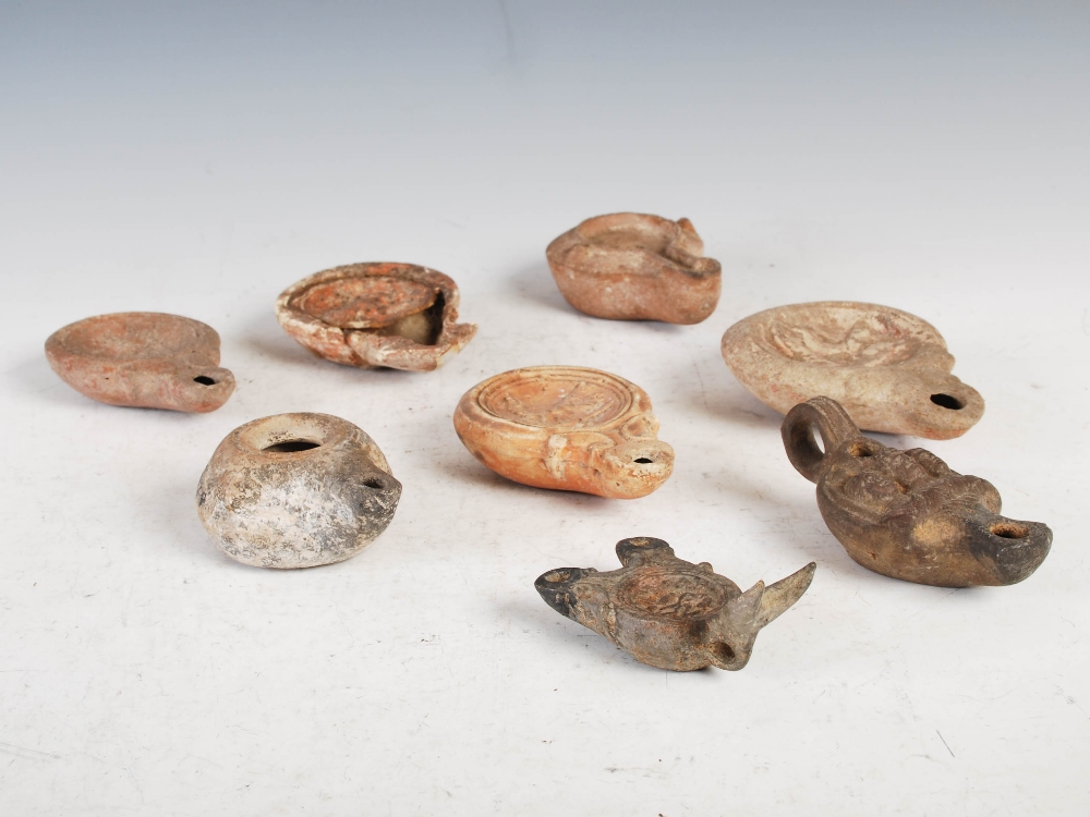 Antiquities- A collection of eight Ancient Roman terracotta oil lamps, comprising; one plain oil