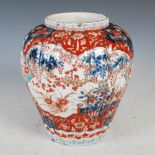 A late 19th century Japanese Imari jar, of ribbed tapered cylindrical form decorated with shaped