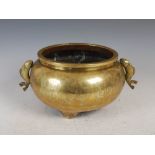 A Chinese bronze twin handled censer, Qing Dynasty, with incised decoration of six circular shaped