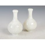 A pair of Chinese opaque white glass bottle vases, Qing Dynasty, decorated in relief with flower