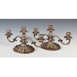 A pair of early 20th century white metal Art Deco style three light candelabra, mounted on shaped