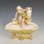 A Royal Dux porcelain centrepiece, moulded with maiden looking into a shell shaped bowl, applied and