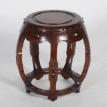 A Chinese dark wood barrel shaped stool, 20th century, the circular panelled top within a studded