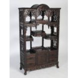 A Chinese dark wood display cabinet, Qing Dynasty, the rectangular top with domed centre section