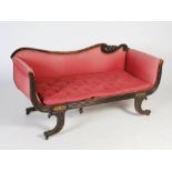 A Regency mahogany and brass inlaid sofa, the scroll carved top rail above an upholstered back and
