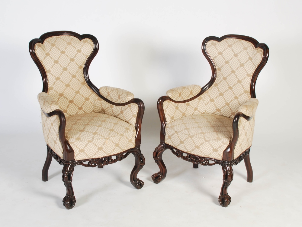 A pair of Chinese dark wood upholstered armchairs, Qing Dynasty, the shaped back, arms and stuffover