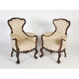 A pair of Chinese dark wood upholstered armchairs, Qing Dynasty, the shaped back, arms and stuffover