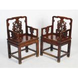 A pair of Chinese dark wood armchairs, Qing Dynasty, the rectangular backs carved and pierced with