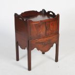 A George III mahogany bow front tray top commode, the shaped rectangular top with shaped gallery and