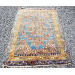 A Persian rug, late 19th/early 20th century, the rectangular blue ground field centred with a