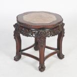 A Chinese dark wood jardiniere stand, Qing Dynasty, the shaped circular top with mottled red and
