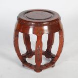 A Chinese dark wood barrel shaped stool, 20th century, the circular panelled top within a studded