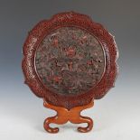 A Chinese cinnabar lacquer dish, Qing Dynasty, of shaped circular form with relief carved decoration
