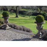 A pair of cast iron garden urns, of campagna form, with applied mask roundels and cast laurel wreath