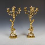 A pair of late 19th century three light candelabra, cast with putti supporting three scroll branches