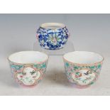 A pair of Chinese porcelain pink ground wine cups and a Chinese porcelain blue ground jar, Qing