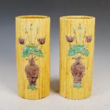 A pair of Chinese porcelain yellow ground bamboo form vases, bearing Qianlong seal marks but