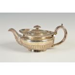 A George IV silver teapot, London, 1820, makers mark of W.E, circular shaped with part gadrooned