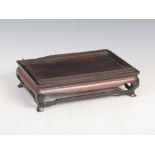 A Chinese dark wood stand, Qing Dynasty, the rectangular panel top with a short raised gallery,