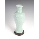 A Chinese porcelain celadon vase, Qing Dynasty, decorated in relief with peony and stylised foliage,