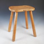 Mouseman - a carved oak cow stool, the shaped top with an adzed finish raised on four tapered