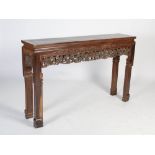 A Chinese dark wood altar table, early 20th century, the panelled rectangular top above a relief