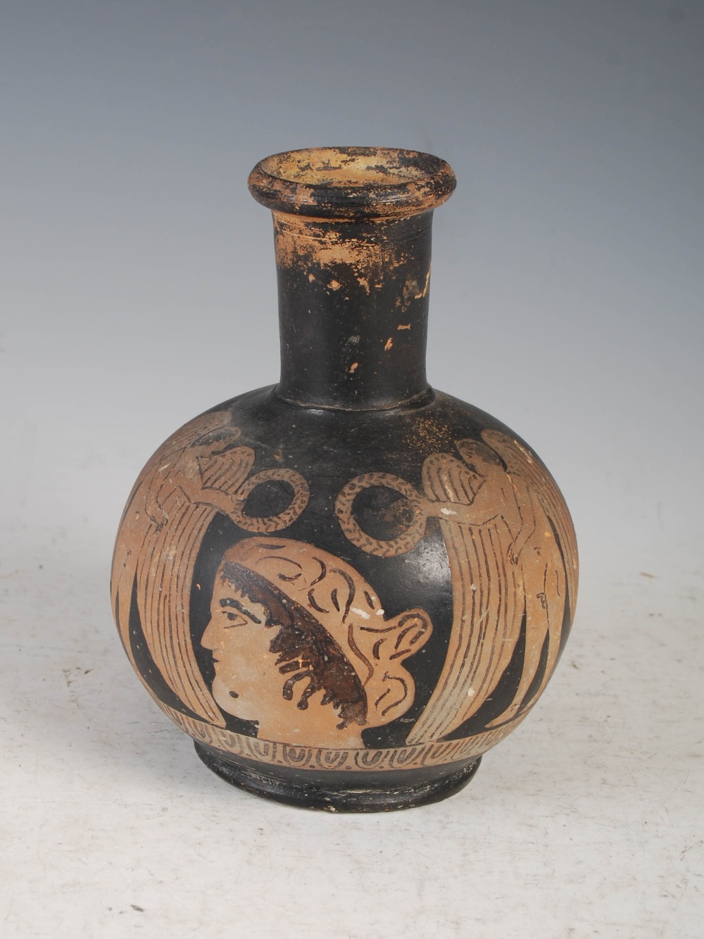 Antiquities- An Ancient Roman Attic black terracotta jug/ aryballos, decorated with central portrait