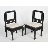 A pair of Chinese dark wood side chairs, Qing Dynasty, the open rectangular backs with foliate