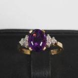 An 18ct gold and white metal amethyst and diamond set cocktail ring, centred with an oval faceted