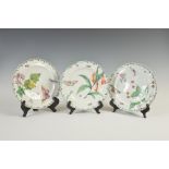 Three 18th century Chelsea porcelain plates, decorated with flowers, fruit and foliage, butterflies,