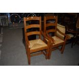 PAIR OF FRENCH OAK LADDER BACK CARVER ARMCHAIRS WITH RAFFIA SEATS