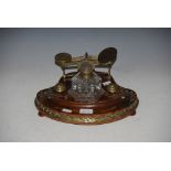 VICTORIAN WALNUT AND BRASS MOUNTED DESK STAND CENTRED WITH A CLEAR GLASS HEXAGONAL SHAPED INKWELL,
