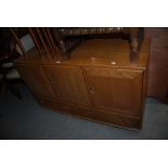 MID 20TH CENTURY OAK STRAIGHT FRONT ERCOL STYLE SIDEBOARD WITH THREE PANELLED DOORS AND TWO FRIEZE